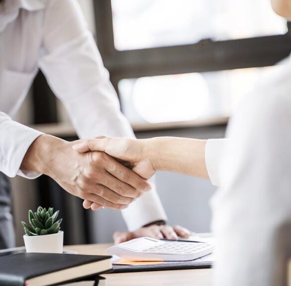 Business executives shaking hands after meeting at office, colleagues management